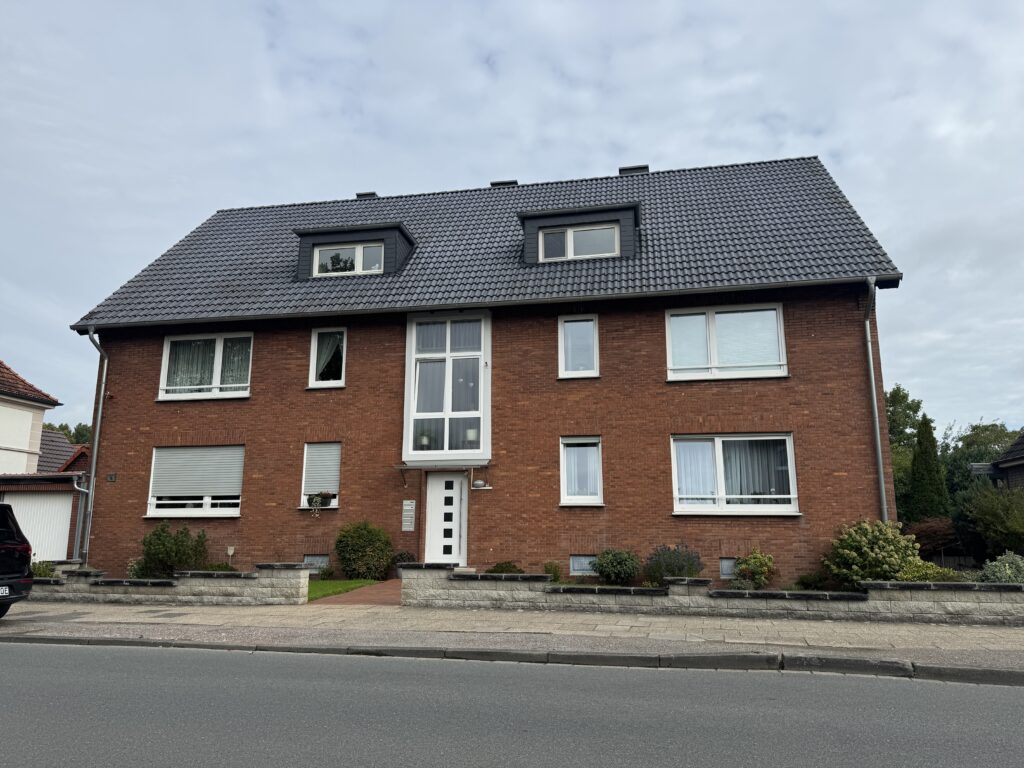 Bodenaufnahme der Immobilie von der gegenüberliegenden Straßenseite mit Straße im Vordergrund